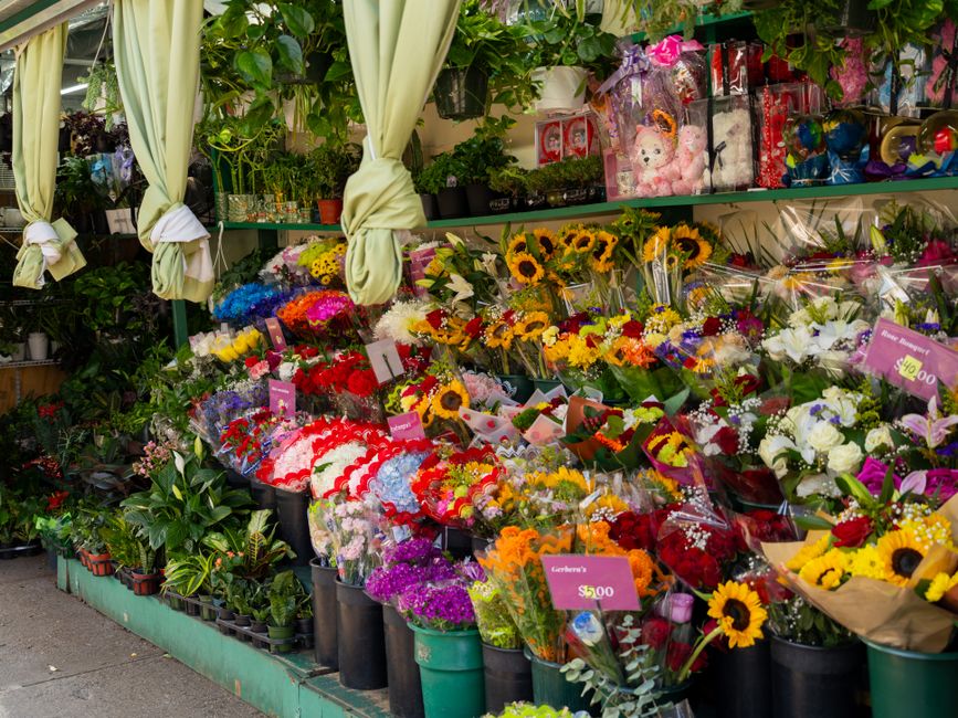 A vibrant display of fresh floral bouquets outside flowersenfield.co.uk, showcasing a variety of flower types including sunflowers, roses, carnations, and lilies wrapped in clear and decorative paper.